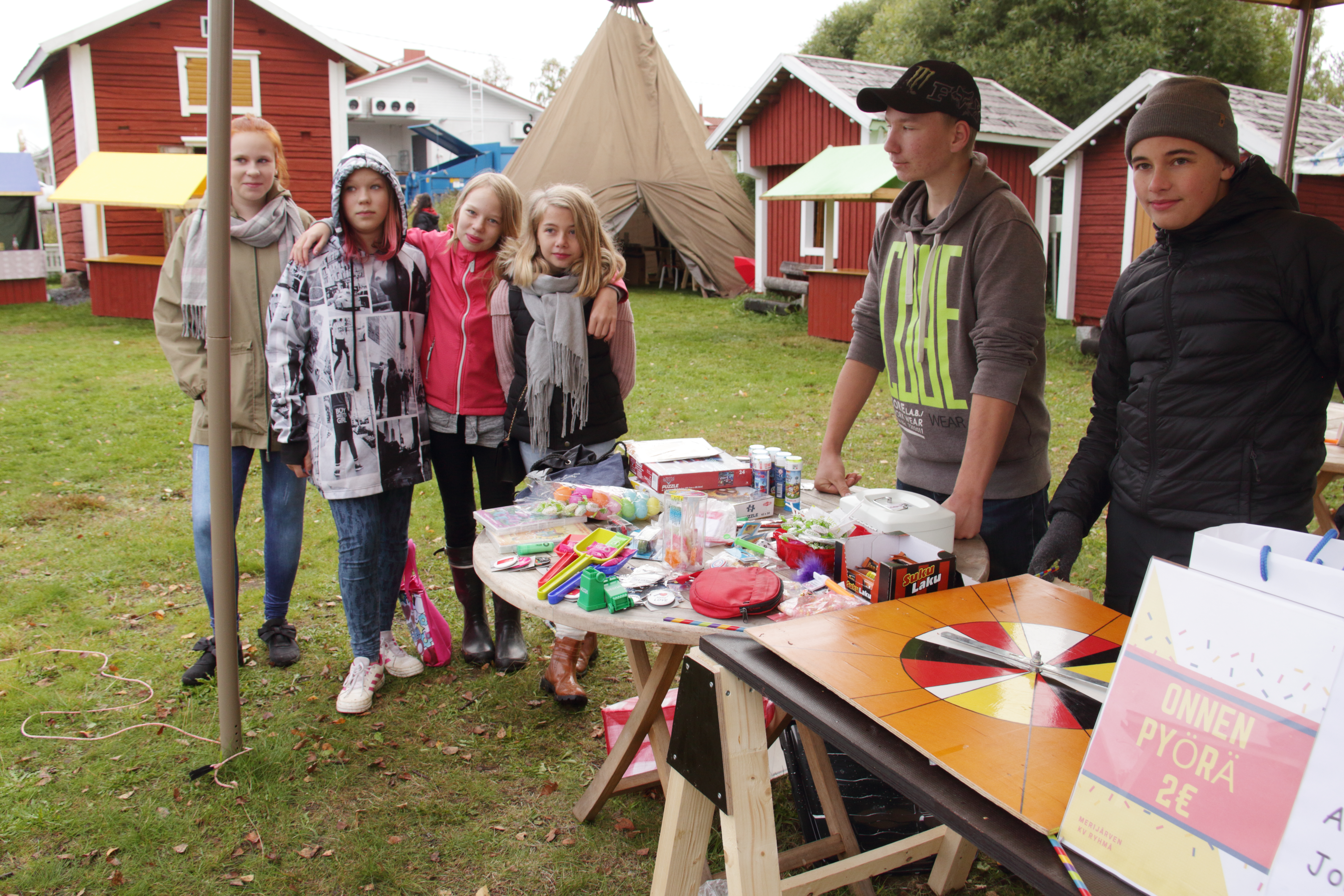 Oskari Saukko (oikealla) ja Sulo Ovaskainen myivät arpoja ja pitivät onnenpyörää. Asiakkaina Oona Jukkola (vasemmalla), Aada Jukkola, Anna Moliis ja Iida Saukko.