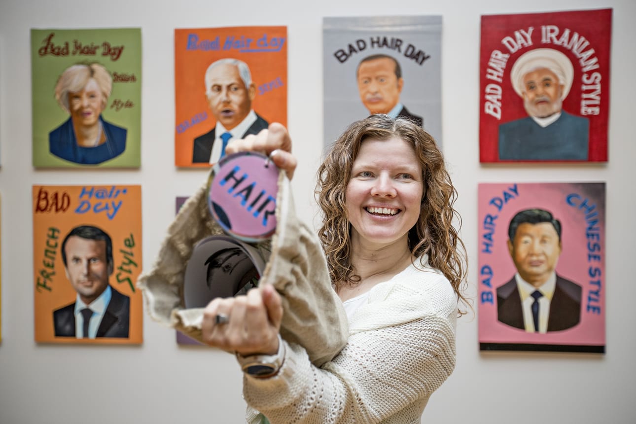Museolehtori Laura Lampinen esittelee tehtäväpussin sisältöä. Tehtäviin kuuluu esimerkiksi piirtää Sauli Niinistölle hiukset ja etsiä yksityiskohtia Riiko Sakkisen feat. Louis Houenouden teoksesta Bad Hair Day Leaders (2018).