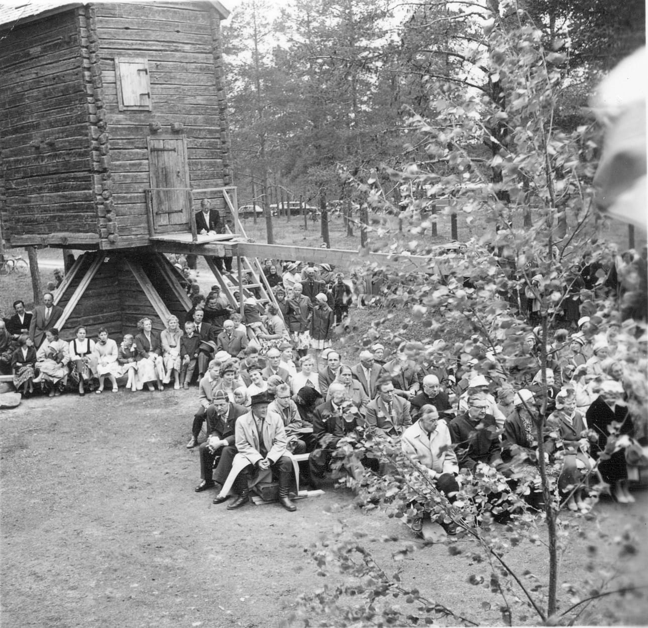 Juhlayleisöä Pudasjärven kotiseutumuseon avajaisissa 19.6.1960. Tuulimyllyn ja makasiinin luokse kokoontunut juhlaväki sai nauttia puheista, musiikista ja lausunnasta.