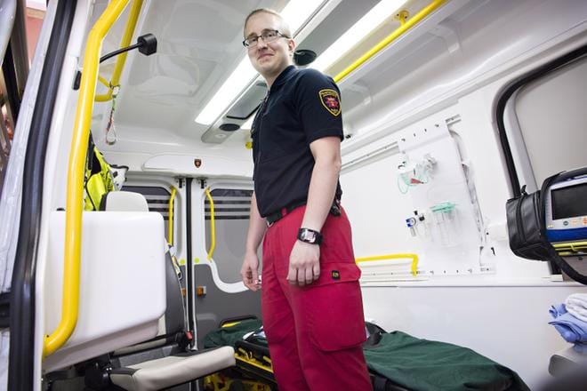Ensihoitaja Joonas Hänninen tarkistaa ambulanssin varusteita. Hänen mukaansa ensihoitajat eivät usein ehdi edes palata asemalle ennen kuin seuraava hälytys jo kutsuu. KUVA: MARTTIINA SAIRANEN