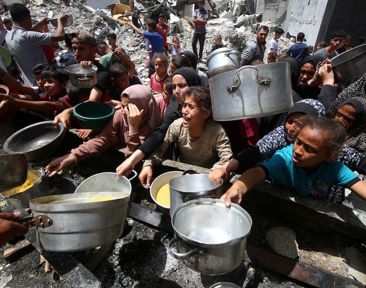 Ihmiset jonottivat kattiloidensa kanssa saadakseen ruokaa Jabaliassa Pohjois-Gazassa toukokuussa.