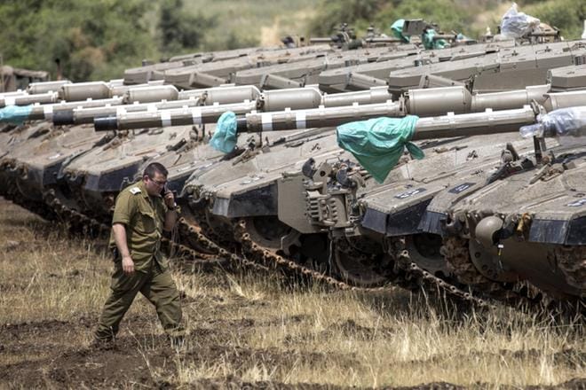 Israelilainen sotilas käveli Merkava-panssarivaunujen luona lähellä Israelin ja Syyrian rajaa Golanin kukkuloilla keskiviikkona. Torstaiaamuna Israel iski Syyriaan ilmasta. KUVA: EPA/ATEF SAFADI
