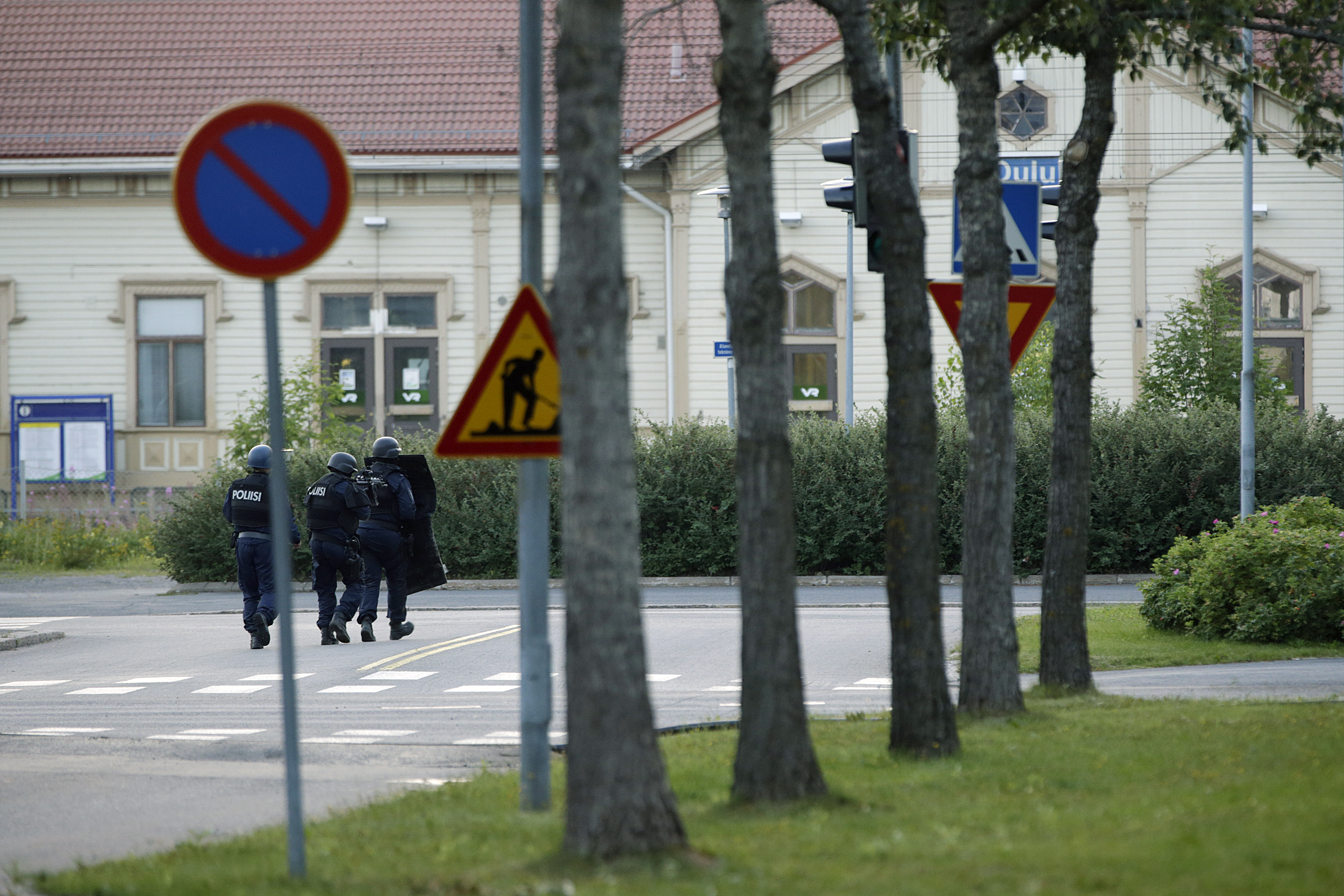 Raskaasti varustautuneita poliiseja poliisilaitoksen tuntumassa.