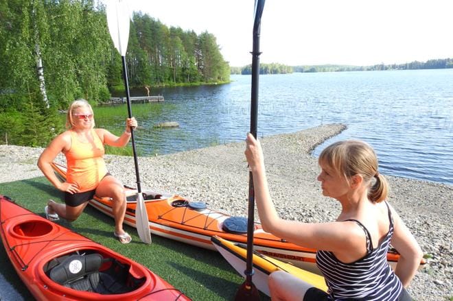 Kaisa Loikkanen (vas.) ja Leena Vuorenmaa neuvovat venyttelemään etenkin selkää ja olkapäitä ennen ja jälkeen melonnan. KUVA: Petri Hakkarainen