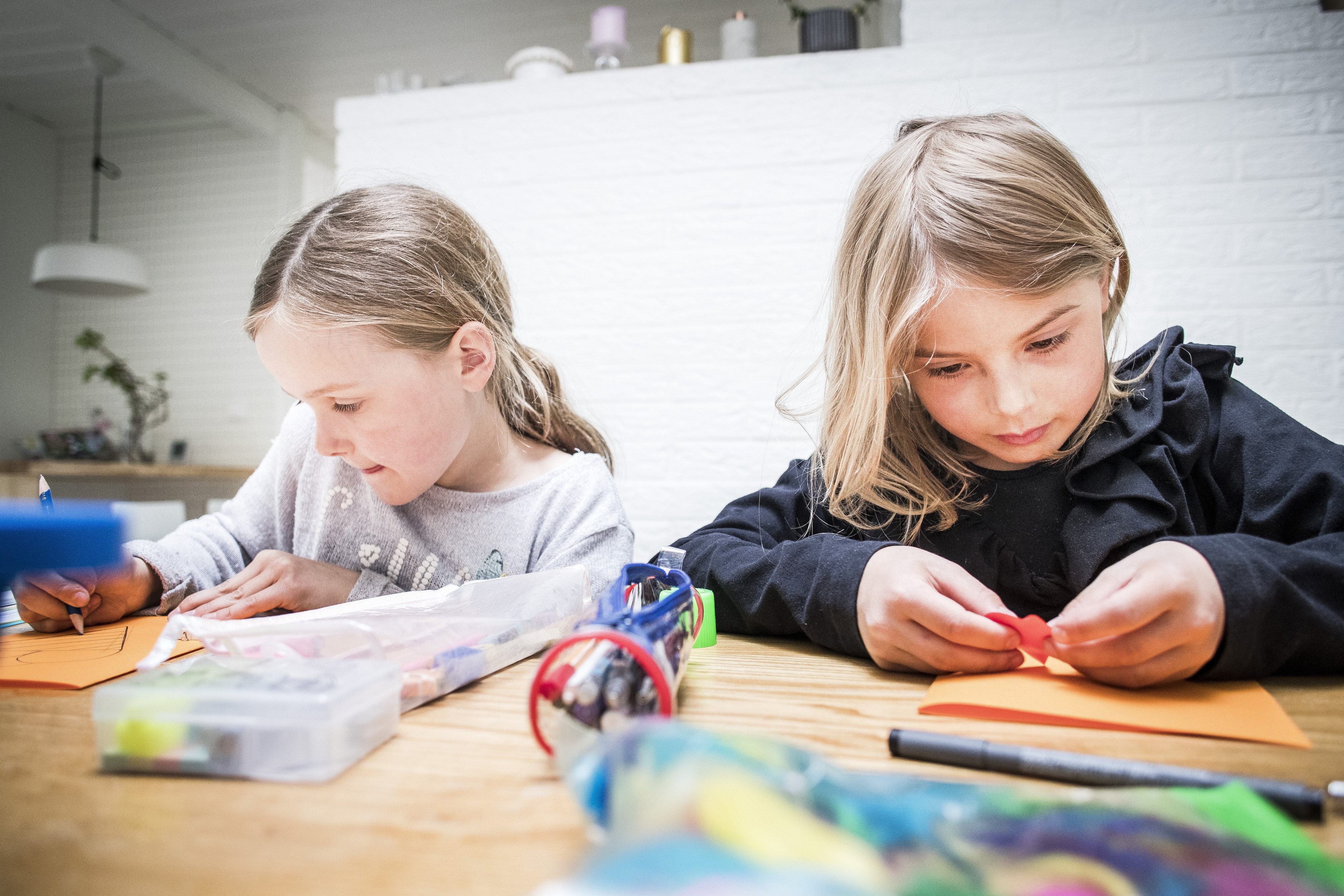 Ellen Savolainen piirtää Tuula-opelle jäätelötötterön. Elea Leppänen päätti leikata Maarit-open korttiin sydämiä. "Meidän ope ainakin suunnistaa kesällä", Elea tietää. Lisäksi hän tietää opettajan lempivärin. Se on oranssi.