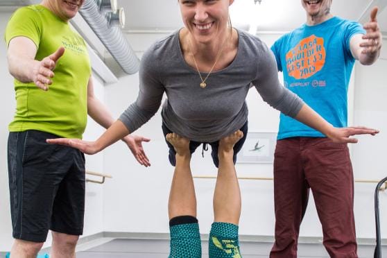 Maria Sumuvuori kokeili acrojoogan Bird-asentoa ensimmäistä kertaa muutamaan vuoteen. Acrojoogaohjaaja Linda Szöken (alla) ohjeistuksella liike onnistui helposti. Wasa upin kiipeilyohjaajat Sami Järvimäki ja Johannes Sumuvuori spottasivat eli varmistivat, että liikkeen suorittamisessa ei varmasti käy mitään. Kuva: Paula Kaskimaa