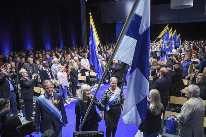 Perussuomalaisten puolueneuvoston kokouksen aluksi Lahdessa saliin tuotiin Suomen lippu. KUVA: KIMMO BRANDT