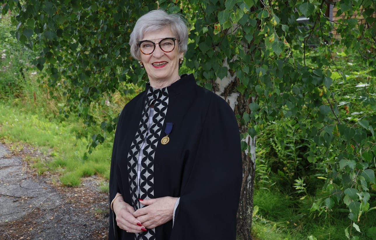 Anneli Kangas pukeutui malliksi mustaan viittaan, jota ritariston jäsenet käyttävät kokouksissaan. Toinen ulkoinen tunnus on numeroitu Wright-mitali. Kankaan rintapielessä on numero 64.