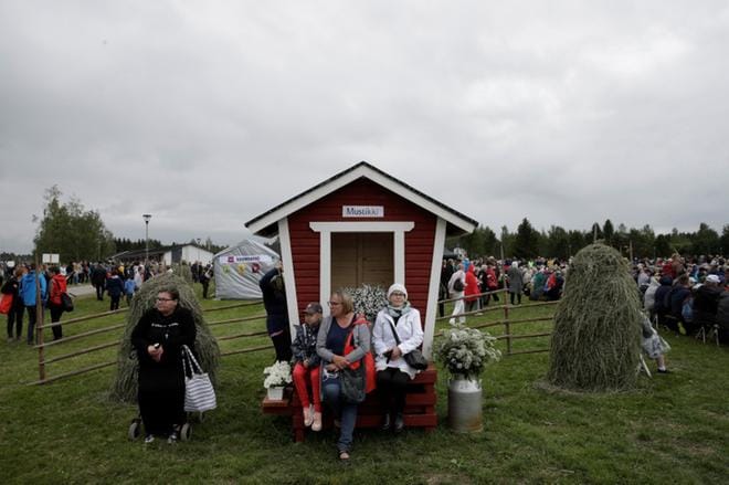 Herättäjäjuhlien yleisö istuu puisilla penkeillä. Viikonvaihteen aikana juhlilla käy arviolta 25 000 ihmistä.