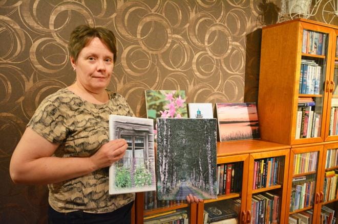Tuija Rinta-Jaskari pitää käsissään kahta valokuvataulua, joiden kuvat saivat satoja tykkäyksiä Facebookissa. Niistä lähti idea toiminimen perustamisesta. KUVAT: MIINA HAKALA