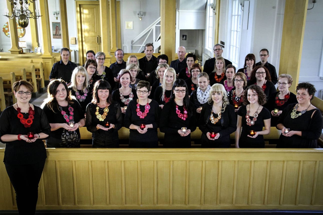 Kuoro Pieni Valo johtajansa Annika Mäkelän (vas.) kanssa kuvattuna kotikirkossaan Haapajärvellä. Ensi lauantaina kuoro laulaa rakastamaansa hengellistä musiikkia Pattijoen kirkossa.