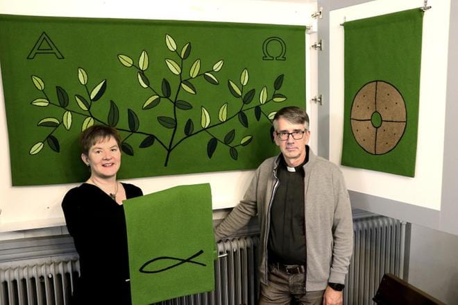 Taiteen maisteri Henna Mantere ja tuomiorovasti Matti Salomäki esittelevät tuomiokirkon uusia kirkkotekstiilejä. Taustalla näkyy vihreä alttarivaate, jossa on elämänpuun kuva. Kirjaliinassa on kala, joka oli alkuseurakunnan käyttämä salamerkki, jolla kristityt tunnistivat toisensa. KUVA: MINNA YLIMÄKI-HEMMINKI