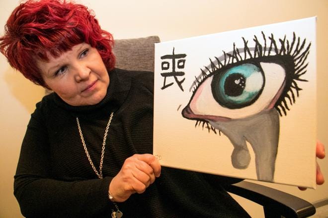 Riitta Koivula esittelee erään 12-vuotiaan tytön maalaamaa taulua, jossa tyttö kuvasi tunnetilaansa isän juomisen aikoihin. Tyttö ei piirtänyt kaatunutta viinilasia tai muuta vastaavaa, vaan kostuneen silmän. Taulun nimi on Suru. Isä raitistui vuoden terapian seurauksena. KUVA: JORMA HAVULA