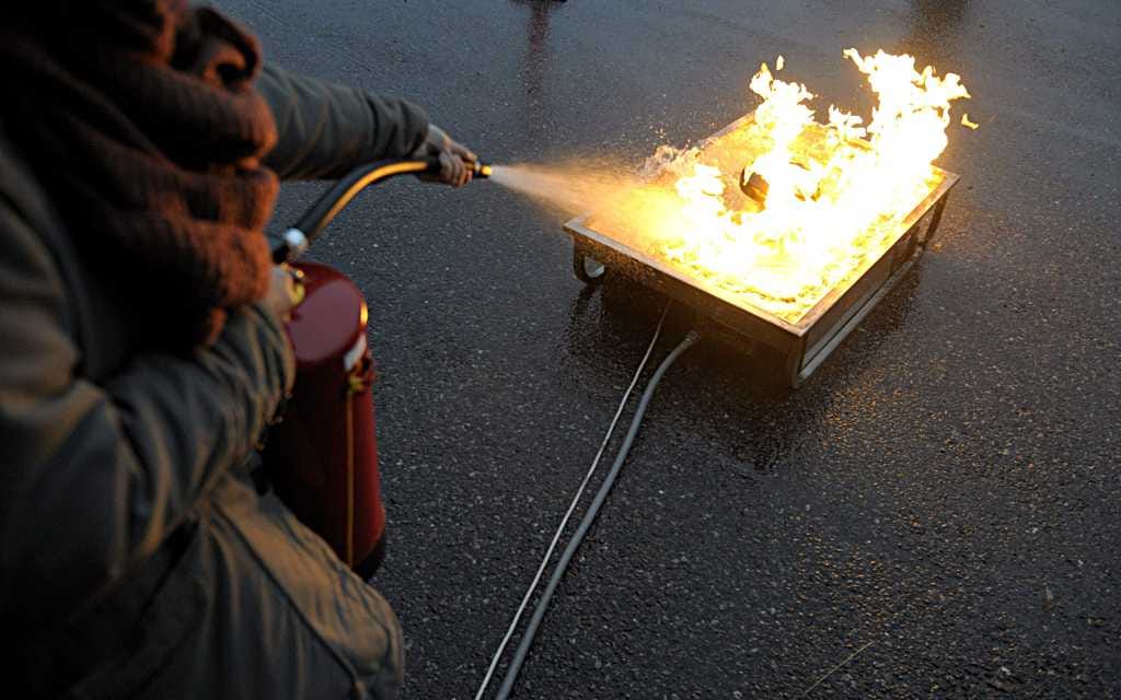 Rasvapalon sammuttaminen käsisammuttimella.