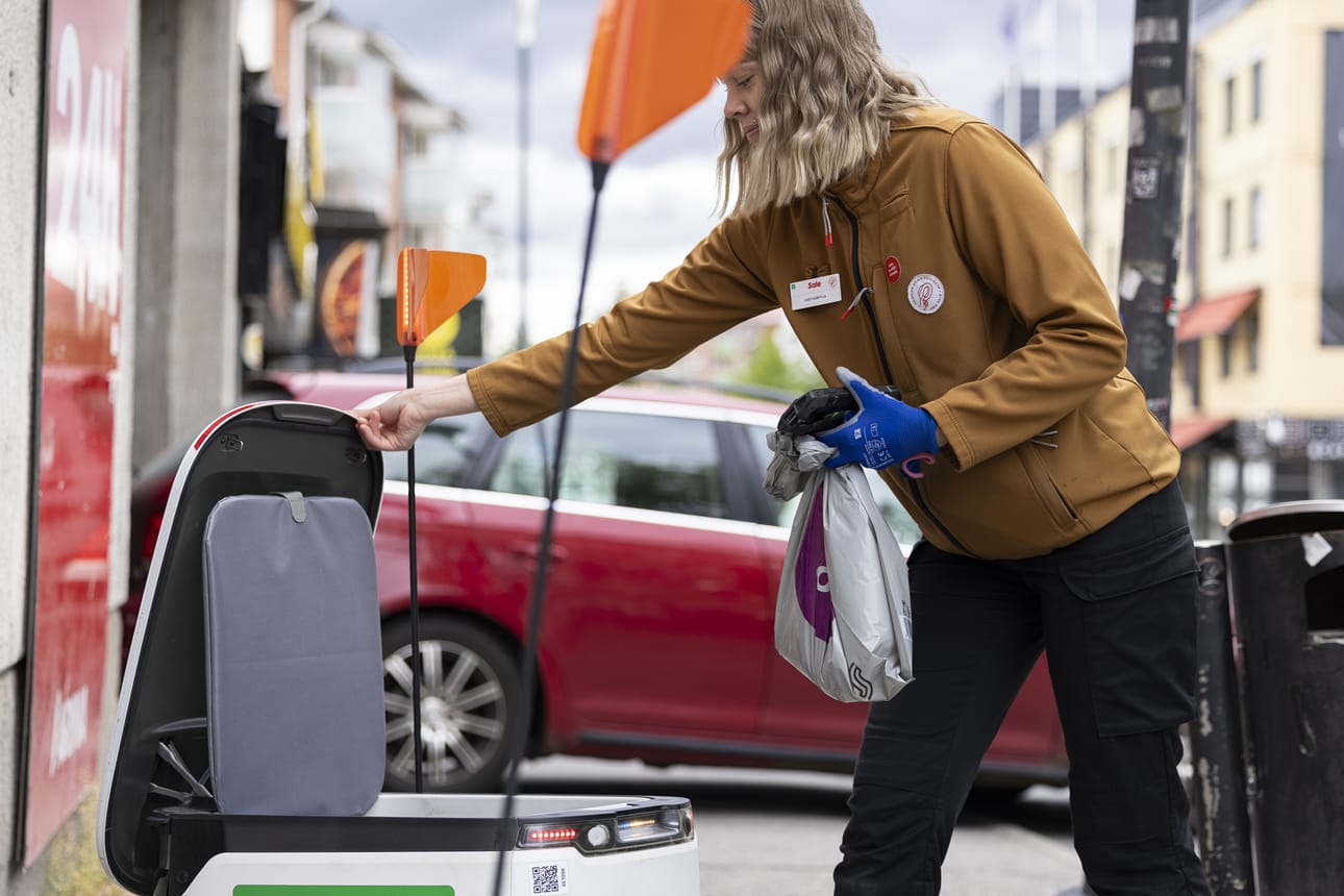 Rovaniemeläisen Sale Lapinmaan vastuumyyjä Marjo-Riitta Kunnari lastaa ruokarobottia matkaan. Kauppa on yksi niistä kolmesta, joissa on ruokarobotit käytössä Lapissa.