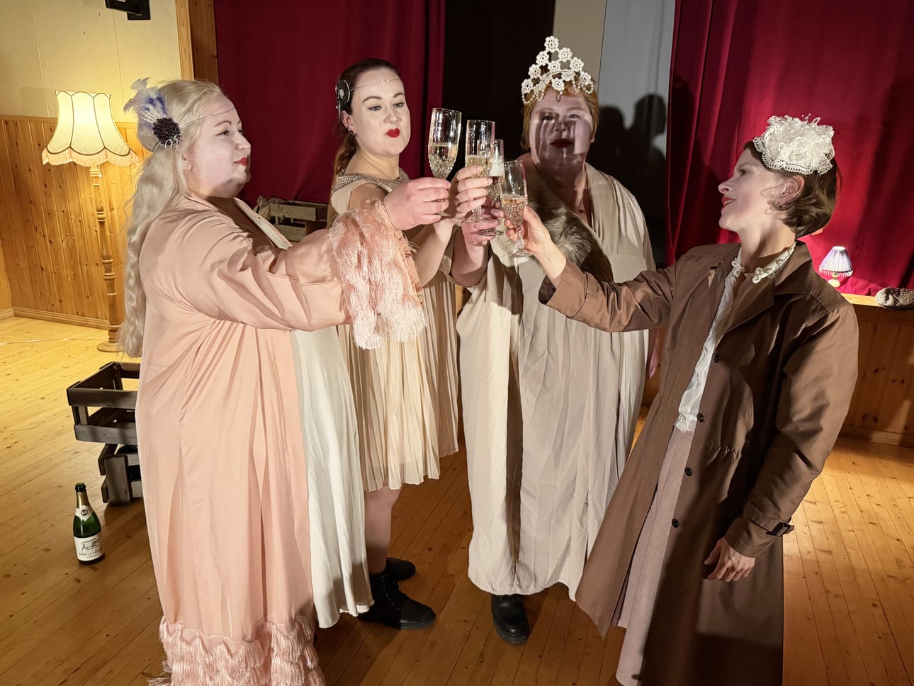 Kolmen koputuksen kapakan kenraaliharjoituksen loppukohtauksessa laseja kilistelevät teoksessa näyttelevät Niina Mäkiharju, Maria Kamula, Anu Holopainen ja Anna Kurikka.