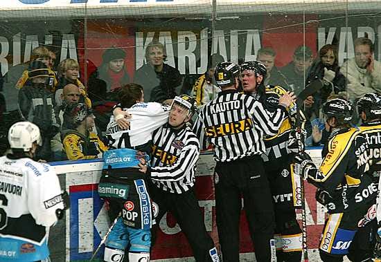 Erotuomarit toppuuttelevat rähinöiviä pelaajia Kärpät-Pelicans-ottelussa tammikussa 2005.