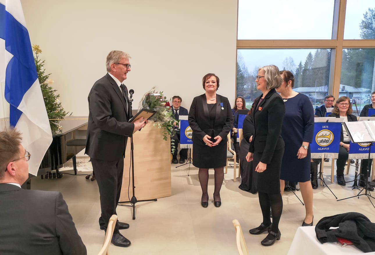 Arto Juurakon palkitsivat vapaa-aikasihteeri Anu Katajamäki (vas.), elintoimalautakunnan puheenjohtaja Anja Kohtamäki ja takaa hieman näkyvä hallituksen puheenjohtaja Maria Keto. Kohtamäki kiitti Juurakkoa monipuolisesta kulttuurialan toiminnasta.