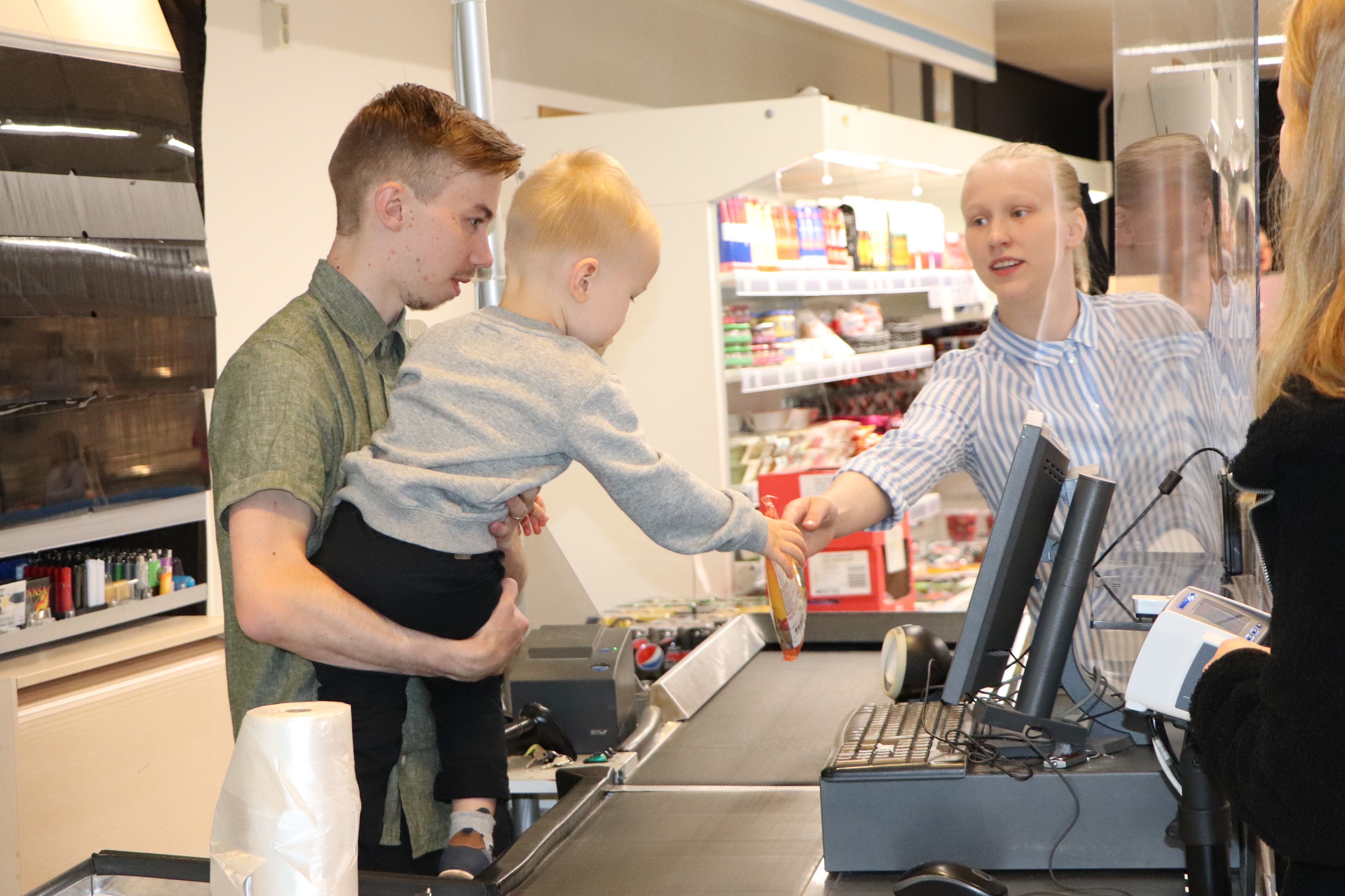 Uunituoreiden K-Kyläkauppiaiden Markus ja Emma Kiviojan 2-vuotias Oliver-poika on innokas apuri myös kassalla. 