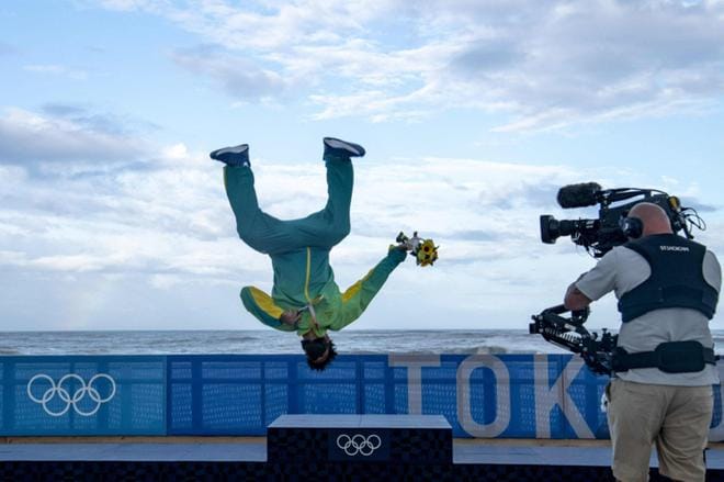 Kaikkien aikojen ensimmäinen surffauksen olympiavoittaja, Brasilian Italo Ferreira irrotteli palkintokorokkeella. Kuva: Olivier Morin / Lehtikuva