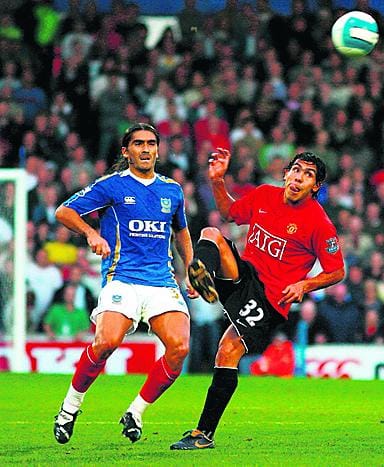 Manchester Unitedin Carlos Tevez (32) siivoaa pallon Portsmouthin Pedro Mendesin ulottuvilta. Viime keskiviikkona Portsmouthissa pelattu valioliigaottelu päättyi tasapeliin 1-1.