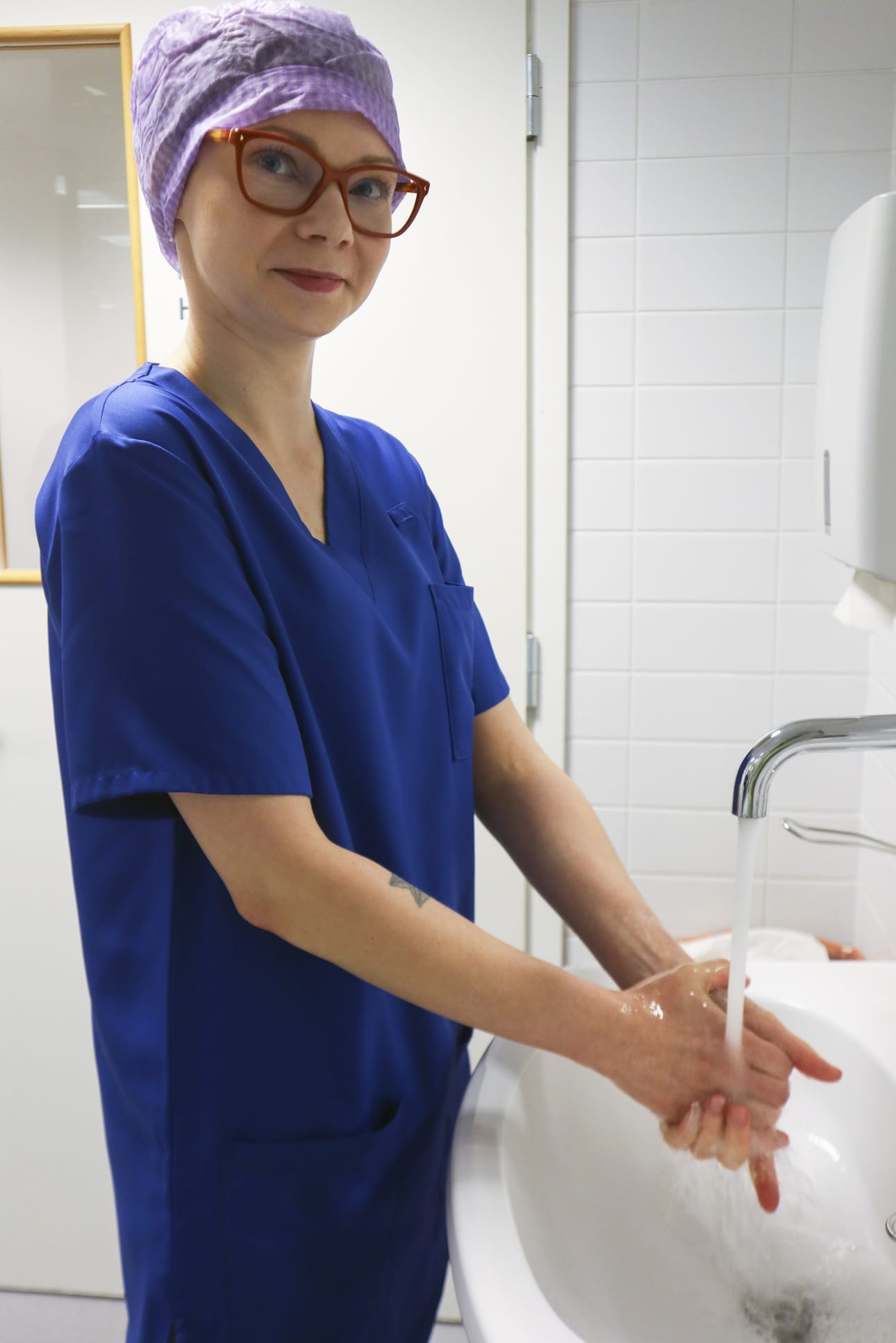 Välinehuoltaja Riikka Frusti pesee ja desinfioi kätensä useita kymmeniä kertoja työpäivän aikana. Hyvä hygienia ja suojavaatteet kuuluvat oleellisesti välinehuoltajan työhön.