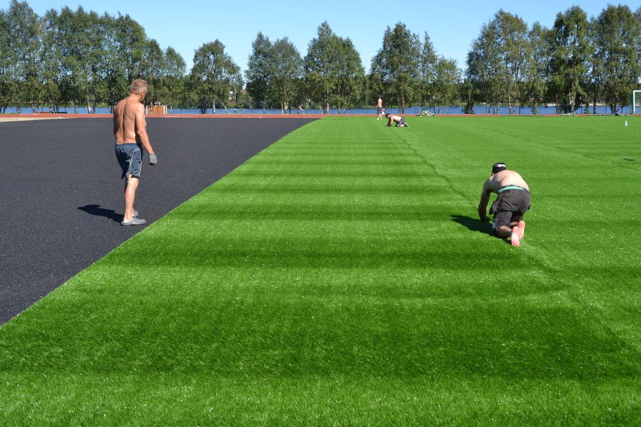 Kuusamon urheilukentän tekonurmipinnoitetta laitettiin paikalleen perjantaina.
