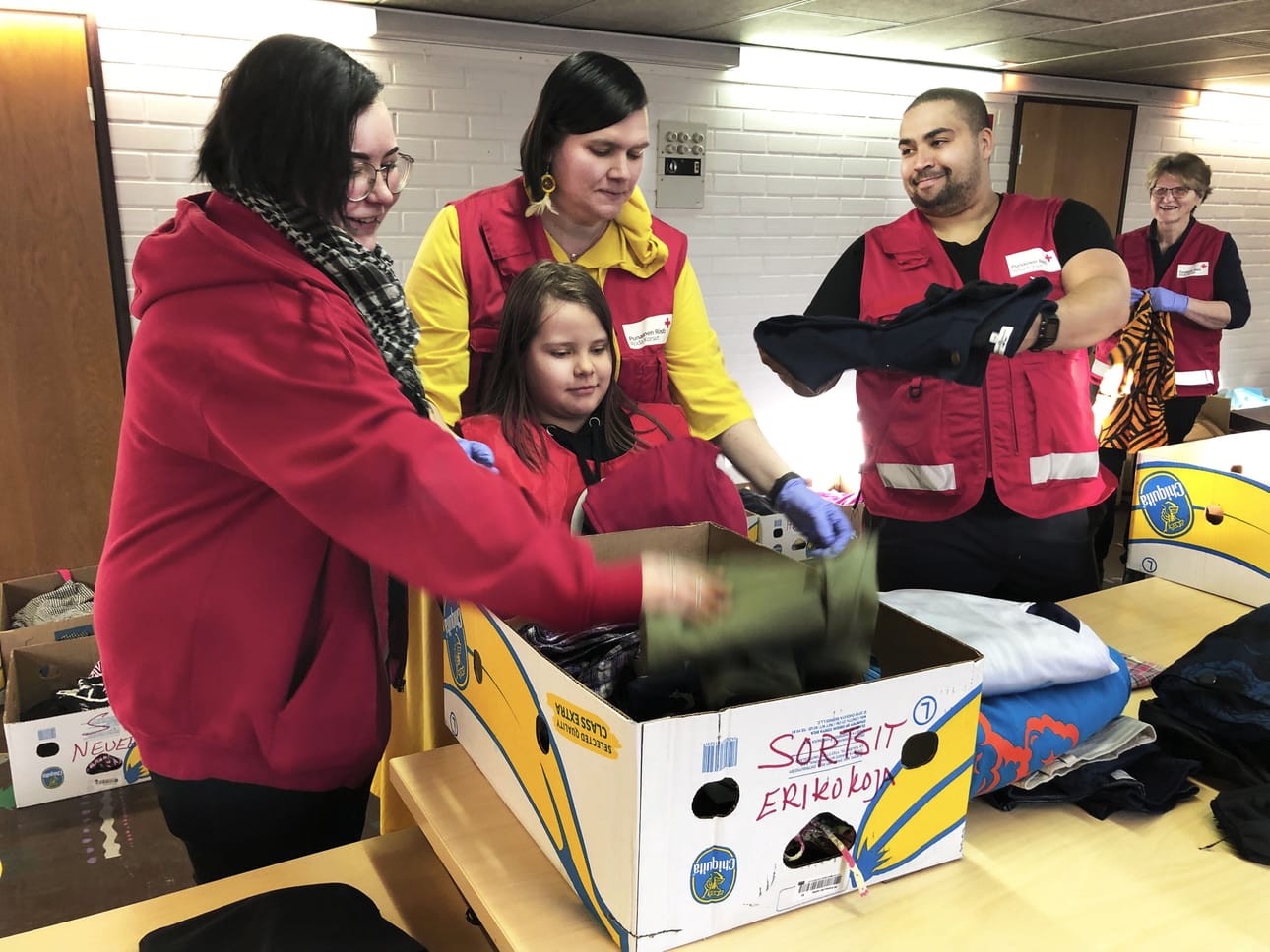 Elisabeth Rintaluoma (vas.), Katja ja Aliisa Palkoma, Terence Sam sekä Eeva-Liisa Välimäki lajittelivat lahjoituksia laatikoihin SPR: avustuspisteellä Ruukintiellä maaliskuussa. Myöhemmin keväällä avustuspiste muutti Koulukadulle. Arkistokuva.