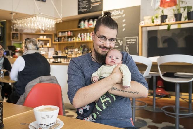 Juho Ljokkoi sylissään puolentoista kuukauden ikäinen vauva. Kuva: Teija Soini