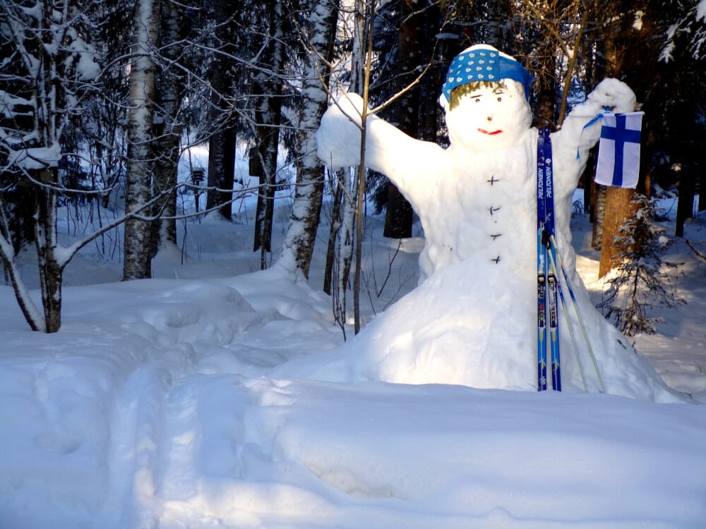 Suomen lippu kruunaa Pentti Hautalan luoman lumiukon tyylin. Se tervehtii tulijoita Hautalan kotipihassa Töysässä.