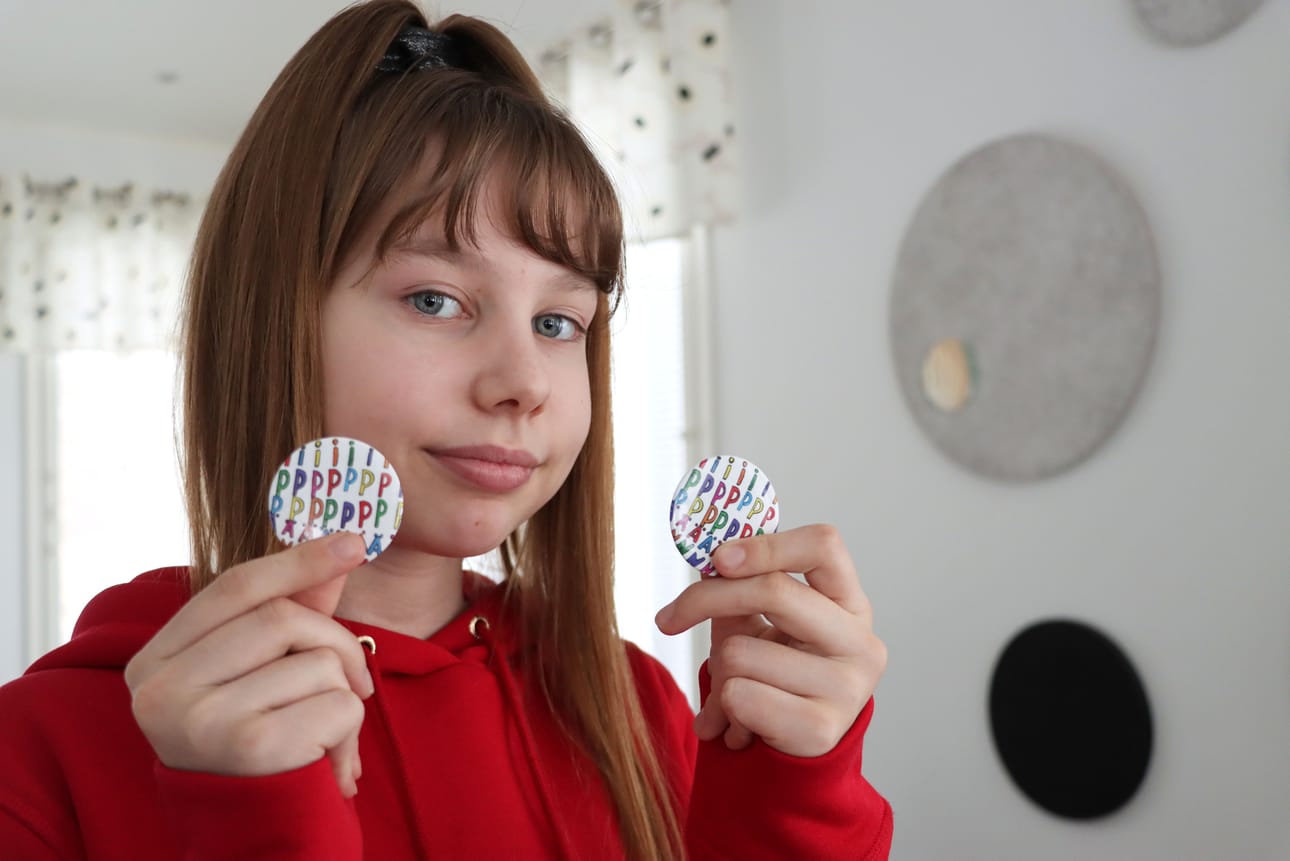 Tästä tuli kyllä aika kiva, toteaa Iiris Vartiamäki, 12, suunnitelmansa pohjalta toteutetusta pinssistä.