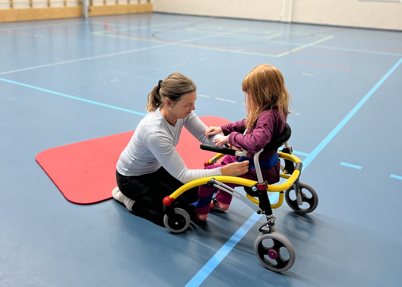 Aurora ja fysioterapeutti Sari koulun salissa dallarin kanssa.