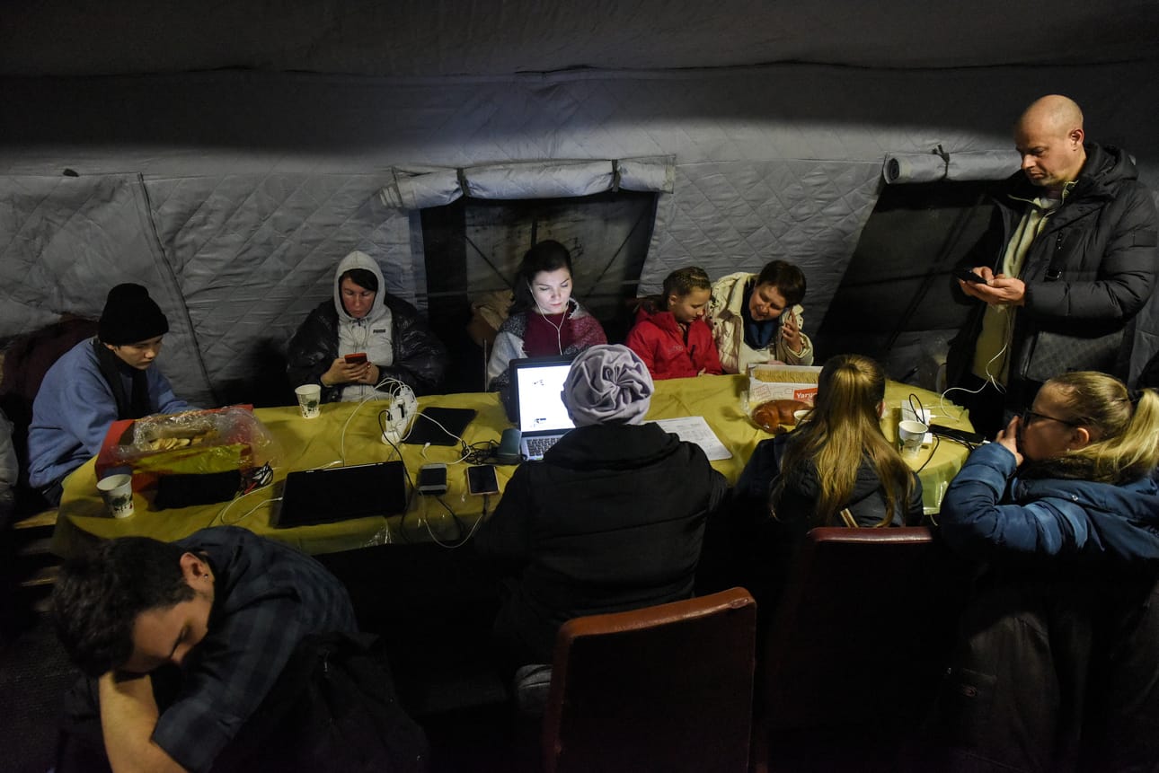 Ihmiset työskentelivät ja latasivat laitteitaan generaattorin ääressä Kiovassa. Kaupunkiin on saatu palautettua osa lämmityksestä edellisten ohjusiskujen jälkeen.