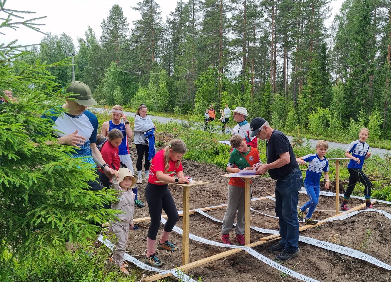 Lähdön tunnelmia. Suunta-Jurvan Hilla Latva sekä Minttu Ikola valmistautuvat eturivissä suoritukseensa ja Sauli Hakala opastaa lähtijää.