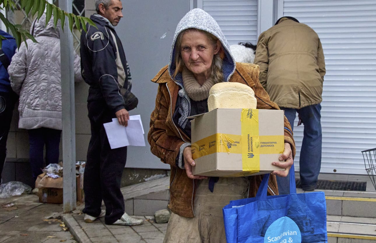 Nainen hakee avustuspakettia uudelleenvallatulla alueella Donetskin alueella tiistaina 11. lokakuuta.