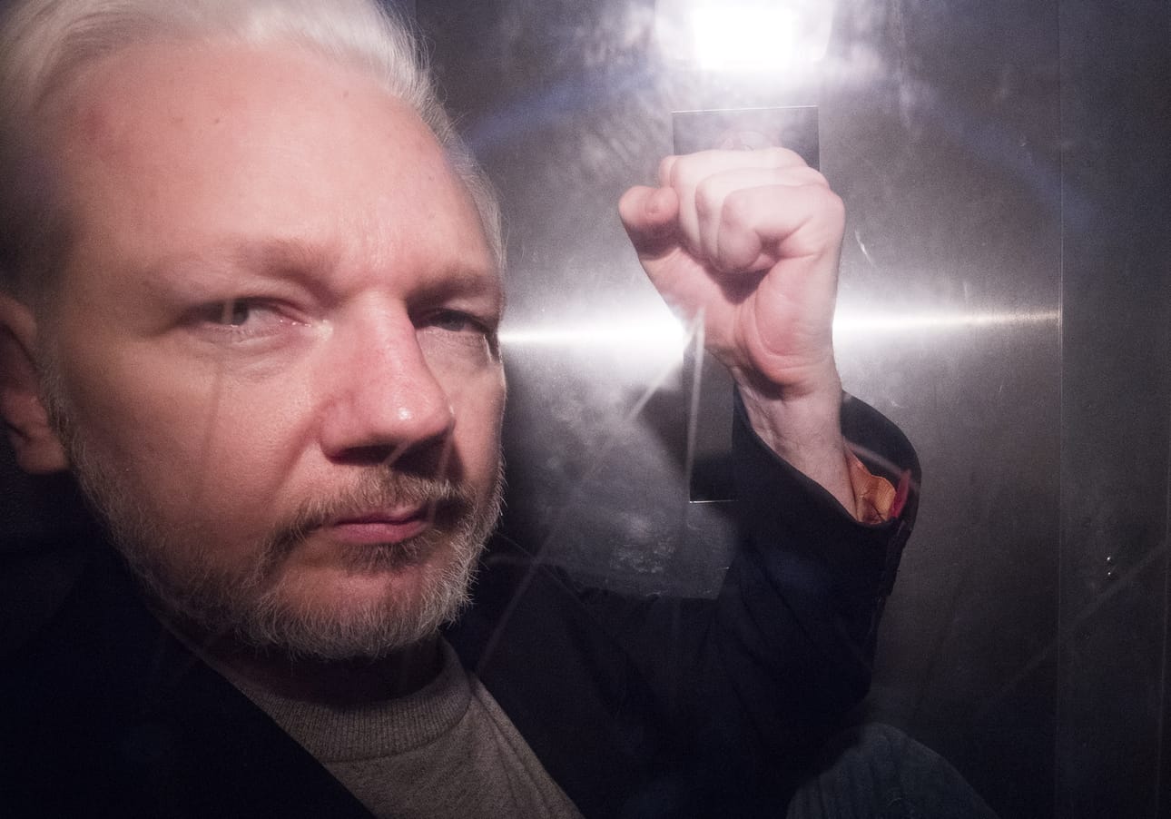 Julian Assange näytti nyrkkiään poliisiautossa matkalla vankilaan oikeuden istunnosta Lontoossa toukokuussa 2019.