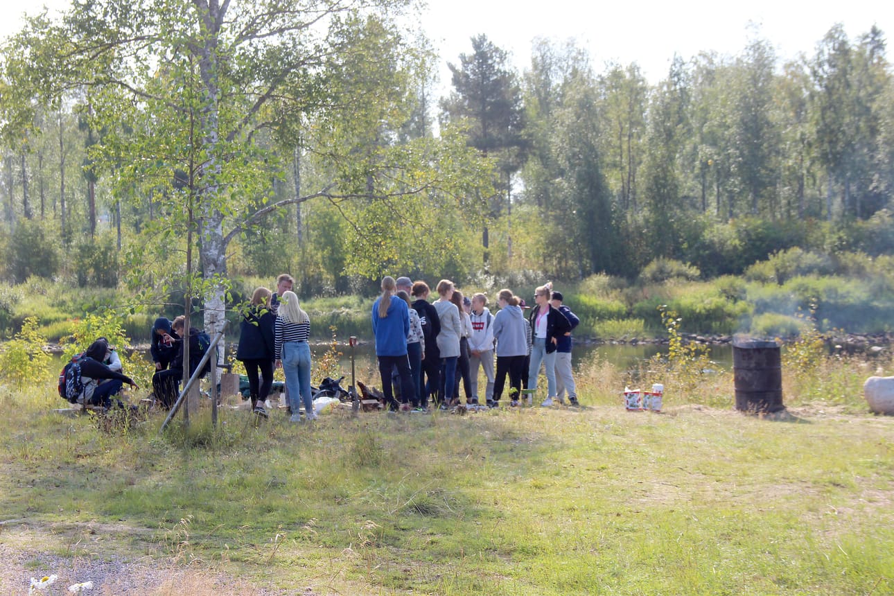 Terva tuoksui Iijoen rannassa Pudasjärvi-päivänä. Tehtaan toimintaa uteliaille esittelivät Hirsikampuksen Jopo-luokan opettaja Ville Eroma ja ohjaaja Janne Laakkonen.