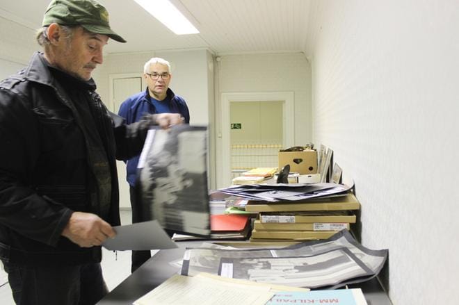 Olavi Laiho ja Veli-Matti Niemelä sekä muut myrkkyläiset rakentavat Paul Norrback -näyttelyä entiseen kirjastoon. Näyttelyä tarvitaan Niemelän mukaan siksi, että kotiseudun historiasta pitää kertoa eteenpäin. – Tämä on meille myrkkyläisille aika vahva asia. KUVA: LOTTA KALLIO