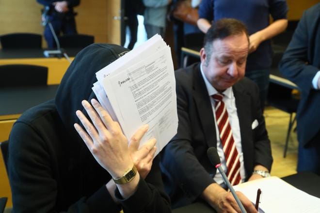 Michael Penttilä (vas.) peitti kasvonsa oikeudenkäynnin aluksi Helsingin käräjäoikeudessa. Penttilä vastasi murhasyytteeseen tiistaina 10. heinäkuuta. Penttilää avusti asianajaja Kari Eriksson. KUVA: Mauri Ratilainen / Com.Pic