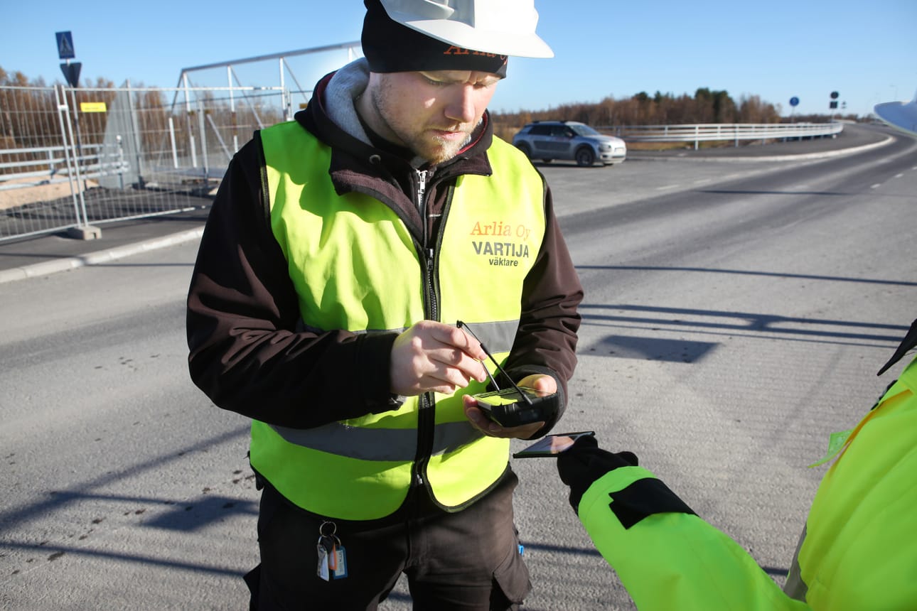 Vartija Sampo Yli-Parkas tarkastaa etälukululaitteella kulkulupakorttia.