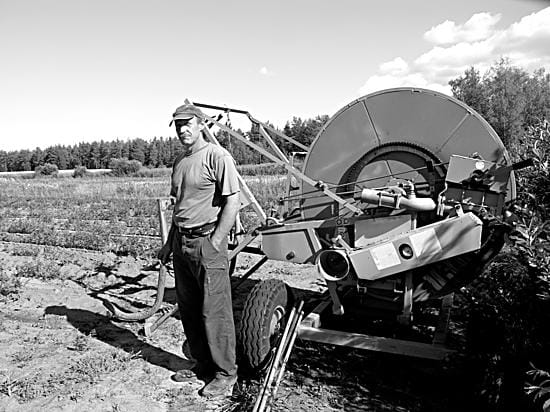Luomuviljelijä Jukka Ukkola pumppaa Siikajoesta vettä kastelulaitteen kautta porkkanaviljelyksille.