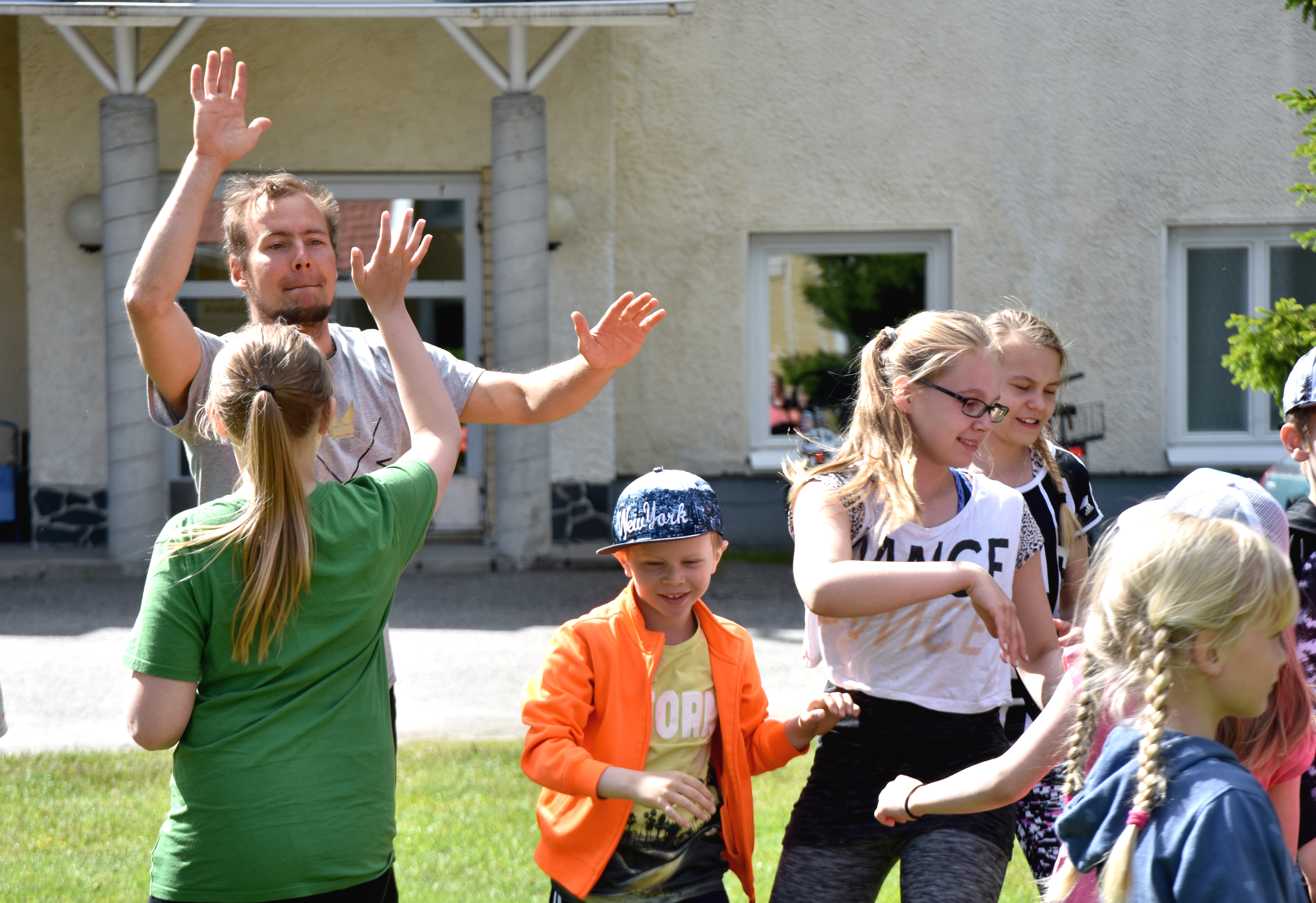Ohjaaja Teemu Syrjälä tervehtii leiriläistä tanssin pyörteissä.