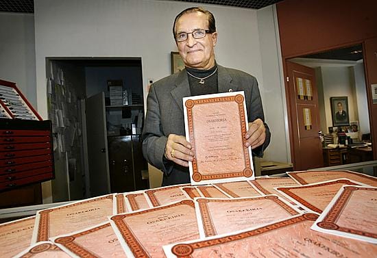 Kalervo Siira esittelee Oulun puhelimen paperisia B-osakkeita.