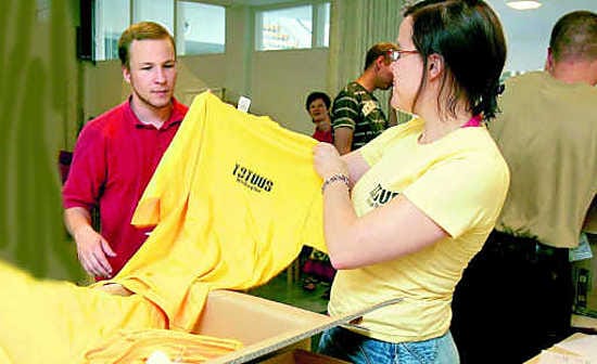 Totuus 07 -tapahtuman palveluita järjestävät vapaaehtoiset tunnistaa keltaisesta paidasta. Palvelutempausvastaava Tanja Runsala ojentaa Veli-Pekka Haaralalle paidan.