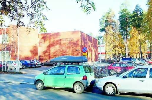 Autojen saartamana. Oulunsuun koulujen kohdalla Aapistielle parkkeeratut autot harmittavat tiellä liikkuvia.
