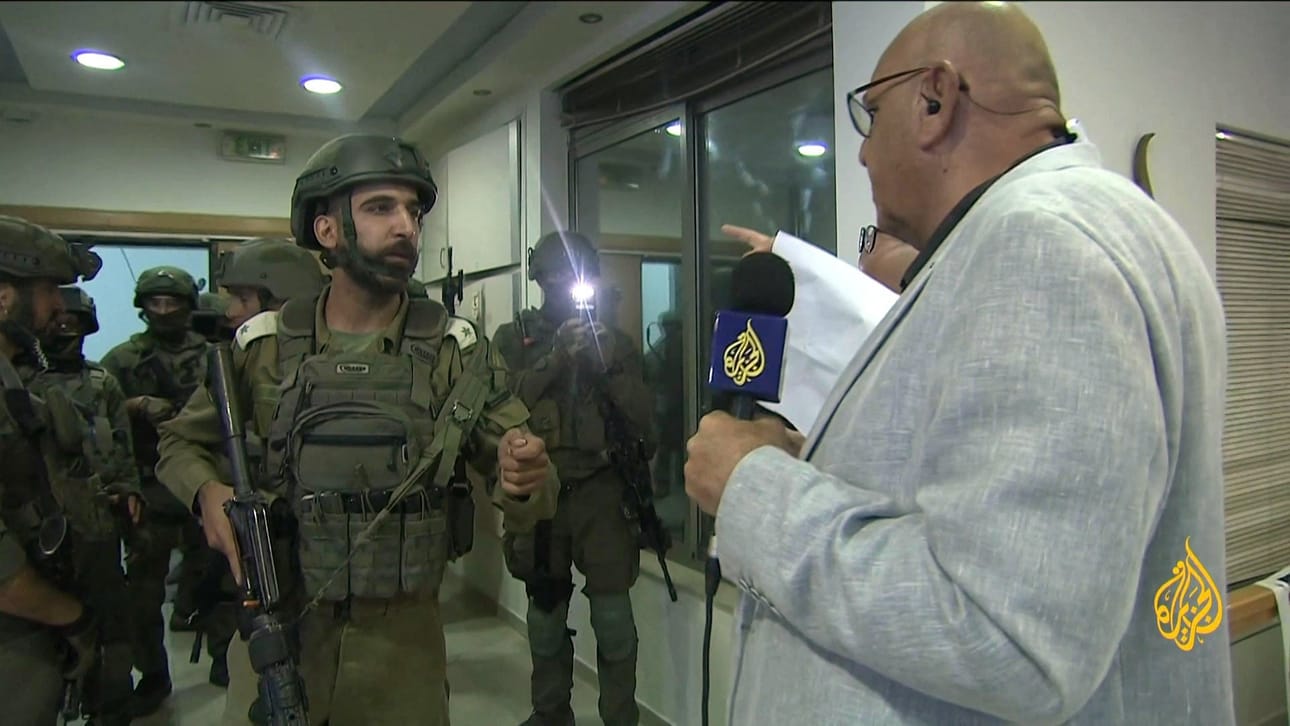Al-Jazeeran Ramallahin-toimiston päällikön Walid al-Omar (oik.) oli kanavan välittämässä kuvassa israelilaissotilaita vastassa, kun nämä toivat 45 päivän sulkemismääräyksen. LEHTIKUVA/AFP