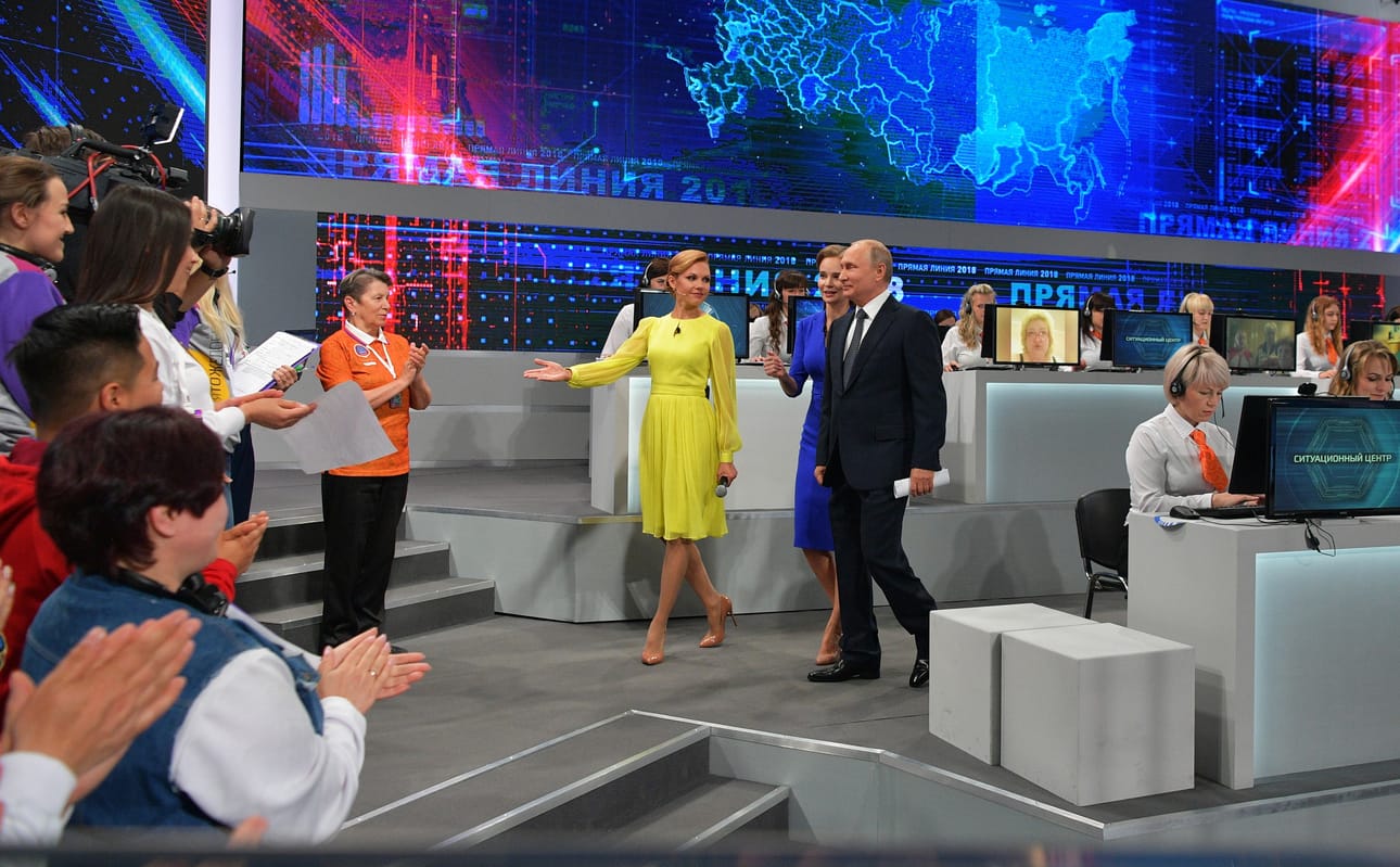 Putin saapui hyväntuulisena huippumoderniin studioon, jossa vapaaehtoiset koostavat hänelle sopivia kansalaisten yli kahdesta miljoonasta kysymyksestä.