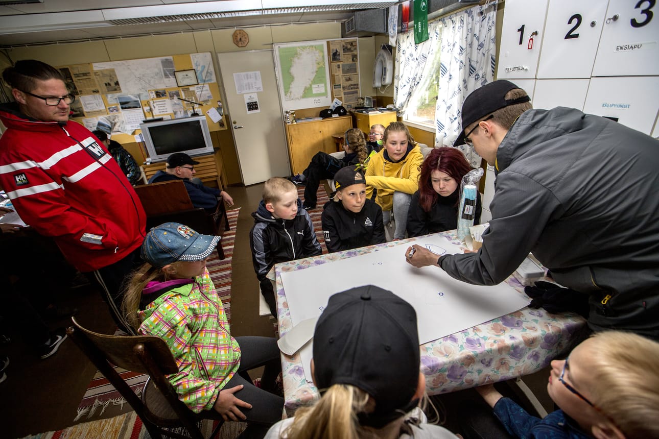Raahen Purjehdusseura kouluttaa lapsia purjehtimaan. Mikko Sipola kertoo pöydän ääressä, miten vastatuuleen luovitaan.