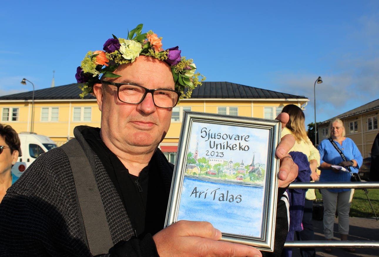 Kauppias Ari Talas sai taulun ja kukkaseppeleen varhain torstaiaamuna.