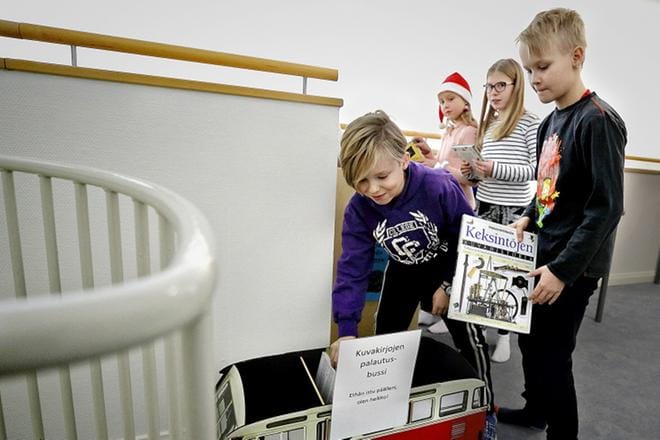 Akseli Hangasluoma nappaa palautusbussista kirjan viedäkseen sen hyllyyn odottamaan seuraavaa lainaajaa. Hyllytysvuorossa oleva nelikko työskentelee mielellään koulun omassa kirjastossa. KUVAT: HEIKKI HAKANEN